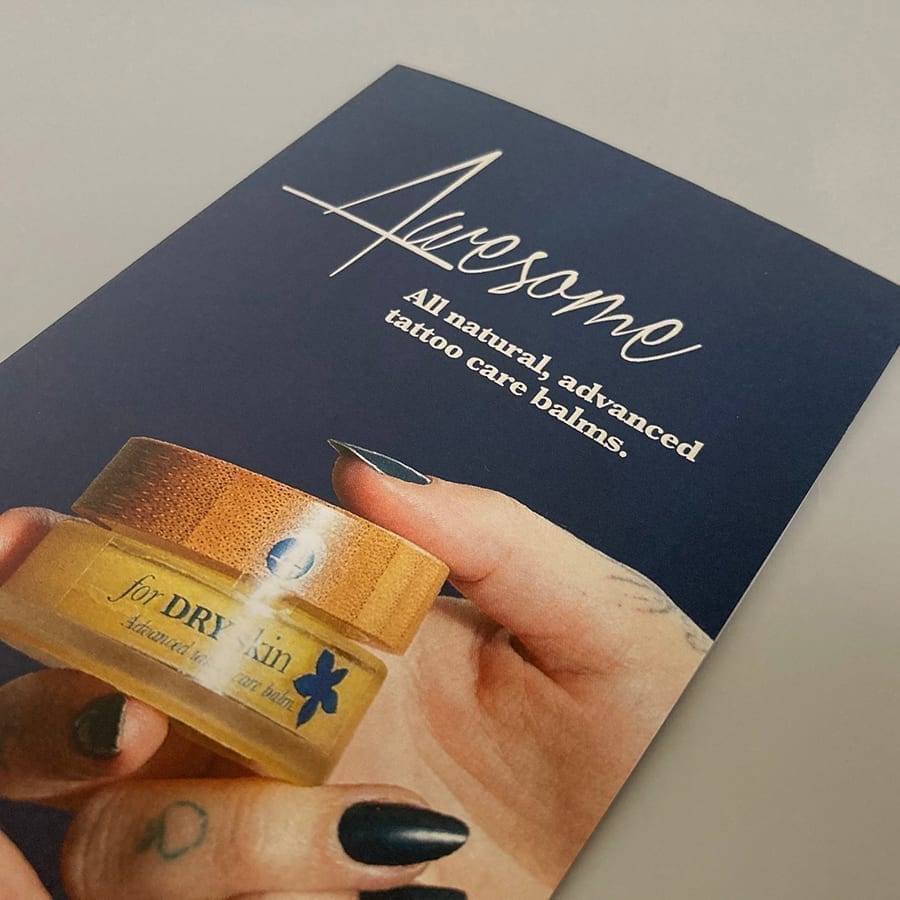 The front of a leaflet for Four Tattoo Care. It's titled 'Awesome' and shows a jar being passed between two tattooed hands.